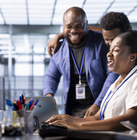 Team of happy engineers laughing, enjoying each other company while working in server farm workplace. Jolly coworkers having fun together during job break in data center office