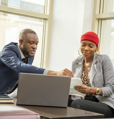 A young black businessman and woman going through some paperwork together